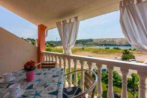 einen Balkon mit einem Tisch und Meerblick in der Unterkunft Apartments Lino in Lopar