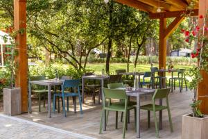 a group of tables and chairs under a pergola at Comfort Lodge Maremma in Grosseto