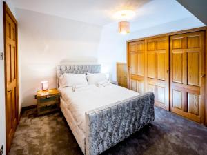 um quarto com uma cama grande e um armário de madeira em Pass the Keys Superb 3 Bedroom Cottage with Sea Views em Anstruther
