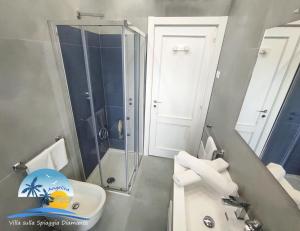 uma casa de banho com um chuveiro, um lavatório e um WC. em Villa sulla Spiaggia Diamante em Belvedere Marittimo