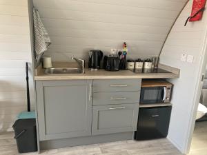 a small kitchen with a sink and a microwave at Duirinish Pods with Private Hot Tubs and Duirinish Bothy with No Hot Tub in Plockton