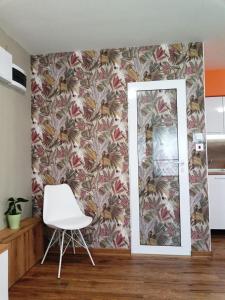 a room with a mirror and a white chair at Студио 55 in Ruse