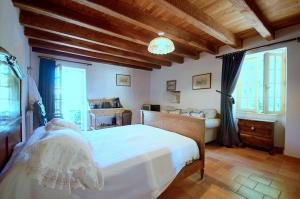 a bedroom with a large white bed and windows at Les Grozilles in Feuillade