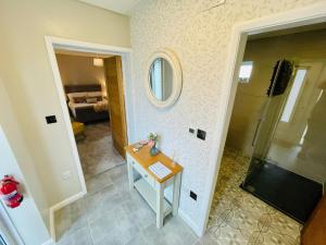 a bathroom with a shower and a table and a mirror at The Old Piggery - Close to Lytham, Preston & Blackpool in Freckleton