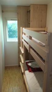 a bunk bed in a room with a window at Camping Brin d'Amour in Les Eyzies-de-Tayac