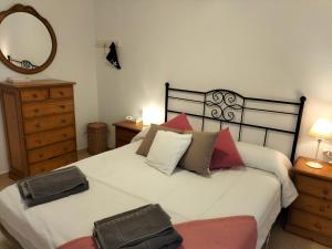 a bedroom with a large white bed and a mirror at Grupoandria Villa Julia in Cala en Forcat +23 photos