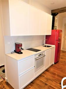 パンプローナにあるAT SARASATE LUXURYのキッチン(白いキャビネット、赤い冷蔵庫付)