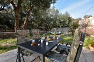 a black table and chairs on a patio at Sunset Cottage in Paramonas +31 photos