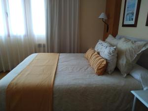 a bedroom with a large bed with pillows on it at Área de Servicio El Cruce in Manzanares