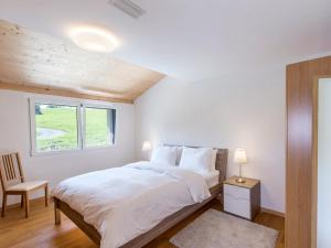a white bedroom with a bed and a chair at Ferienwohnung Jones in Pany