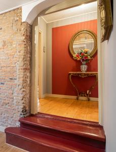 a stairway with a red wall and a mirror at Herberg Het Rechthuis in Rinsumageest