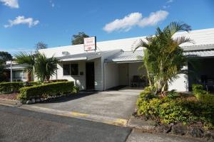 un bâtiment blanc avec des palmiers devant lui dans l'établissement Kallangur Motel, à Kallangur