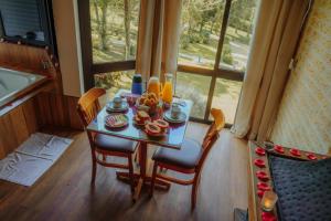 a table with food on it next to a window at Terrazzo dos Alpes in Monte Verde