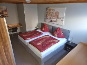 ein Schlafzimmer mit einem Bett mit roten Kissen in der Unterkunft Moving Rooms in Wimpassing