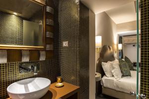 a bathroom with a sink and a bed in a room at Colonna Suite Del Corso in Rome