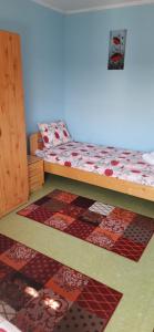 a bedroom with a bed and colorful rugs on the floor at Cazare tudor&abril in Cojocna