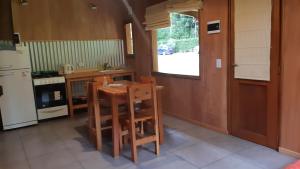 una cocina con mesa y 2 sillas. en Alihuen Cabañas Cab 3 en San Carlos de Bariloche