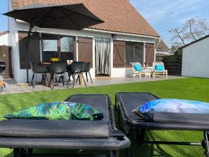 zwei Terrassenstühle und ein Regenschirm auf einem Rasen in der Unterkunft vakantiehuisje 003 in Koksijde