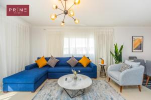 un soggiorno con divano blu e tavolo di Prime Select Sheraton a Il Cairo