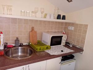 a kitchen counter with a microwave and a sink at Chatka Tatry in Veľký Slavkov +9 photos