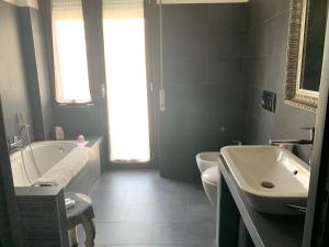 a bathroom with a white tub and a sink at Carolina’S Nest in Casal Palocco