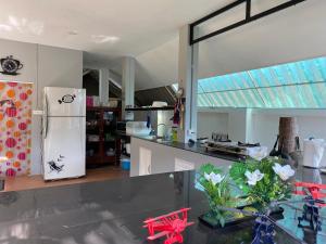 a kitchen with a refrigerator and a counter with flowers at Rungnara pool villa in Chiang Mai