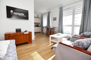 a living room with a couch and a table at Apartamenty Navigator-REZYDENCJA SPACEROWA in Kołobrzeg