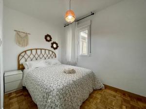 um quarto com uma cama com um edredão branco e uma janela em KLOLA em Ávila