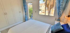 sypialnia z łóżkiem i oknem w obiekcie Przytulny Apartament 100m od plaży w mieście Torrevieja