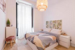 sypialnia z łóżkiem i dużym oknem w obiekcie Plaza Mayor Apartment w Madrycie