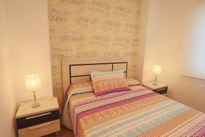 1 dormitorio con 1 cama con 2 mesitas de noche y 2 lámparas en Poeta 2 Bedroom Apartment, en Fuengirola