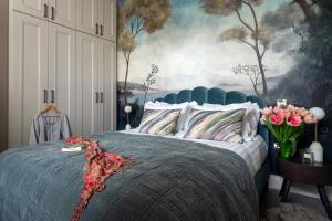 a bedroom with a bed with a painting on the wall at Cathedral Yard - Art Deco Luxury (Exeter) in Exeter