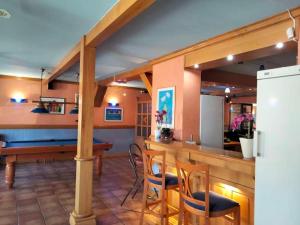 a kitchen with a bar with chairs and a pool table at Zajazd Restauracja Machliny in Machliny