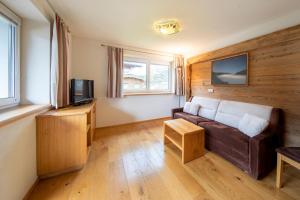 salon z kanapą i telewizorem w obiekcie Apartmenthaus Berndlalm w mieście Neukirchen am Großvenediger
