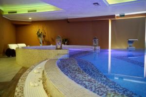 a pool of water in a large room with aitating at Hotel Roscianum Welness SPA in Rossano