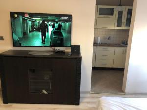 einen TV auf einem Stand in einem Zimmer mit einer Küche in der Unterkunft M.S. Piccolo in Żary