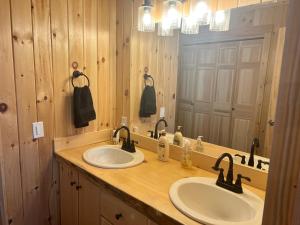 a bathroom with two sinks and a large mirror at Loafers' Lodge in Carrabassett +15 photos