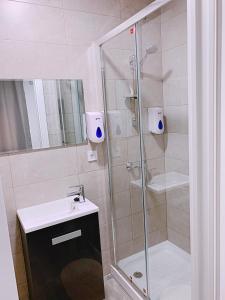 Un baño con ducha, lavabo e inodoro. en Hostal El Castillo Alcala De Guadaira, en Alcalá de Guadaira