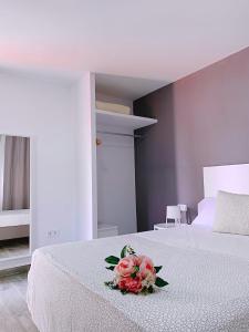a bedroom with a bed with a bouquet of flowers on it at Hostal El Castillo Alcala De Guadaira in Alcalá de Guadaira