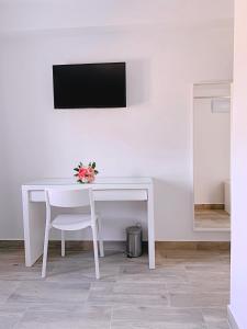 アルカラ・デ・グアダイラにあるHostal El Castillo Alcala De Guadairaの白いデスク(白い椅子付)、テレビが備わります。