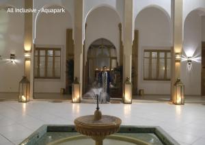 un homme debout dans le hall d'un immeuble avec une fontaine dans l'établissement Valeria Dar Atlas All Inclusive, à Marrakech