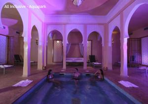 馬拉喀什的住宿－Valeria Dar Atlas All Inclusive，紫色房间游泳池里三个女孩