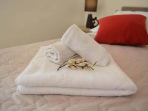 a towel with a flower on top of a bed at Fancy Apartments Dream in Brna