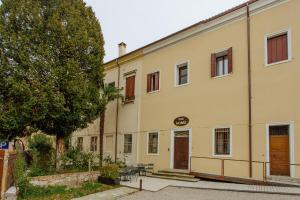 un grande edificio giallo con un albero di fronte di Dadi Home Camera 5 a Padova