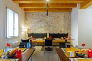 a dining room with tables and chairs and a brick wall at Dadi Home Camera 5 in Padova