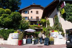 un groupe de personnes marchant devant un bâtiment dans l'établissement Logis Hôtel La Terrasse Fleurie, à Divonne-les-Bains