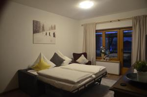 a bedroom with a bed and a desk and a window at Ferienwohnungen Sunshine Stumm in Stumm