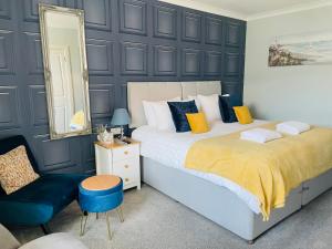 1 dormitorio con cama, silla y espejo en Whinburn Guest House en Fort William