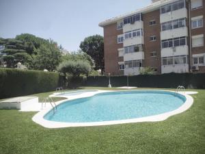 a swimming pool in a yard next to a building at Precioso apto, con piscina en puerto de Cambrils, wifi y parking incluido in Cambrils