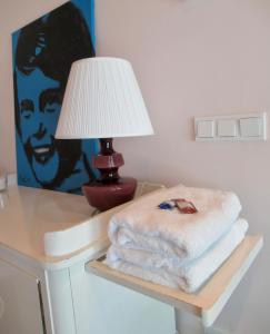 een tafel met een lamp en een stapel handdoeken erop bij B and Be Happy Friesland in Lioessens